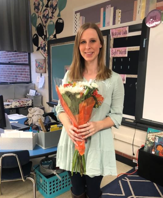 Amanda Hodges in classroom holding flowers