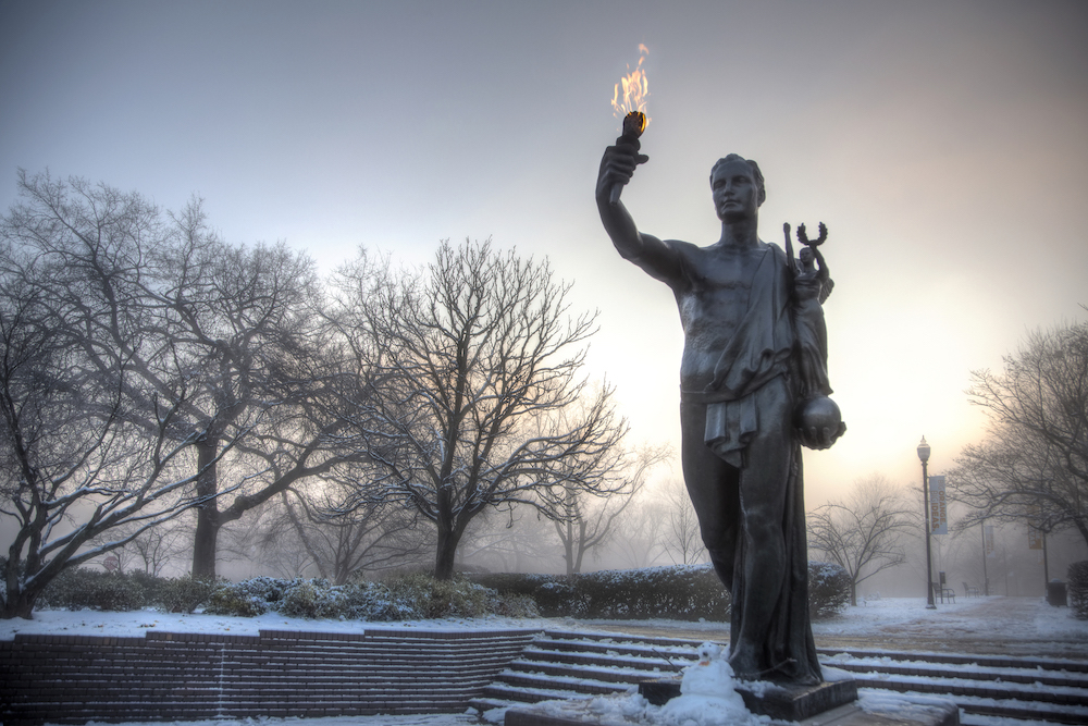 The Torchbearer with a hazy winter sky, lit from behind.