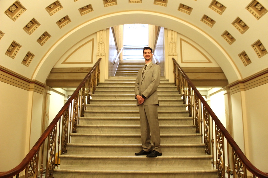 Photo of Benjamin Bridges standing on marble stairs under an arch in Washington, DC.
